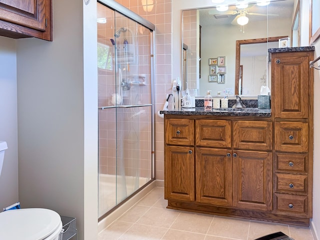 full bathroom featuring toilet, a shower stall, tile patterned flooring, vanity, and ceiling fan