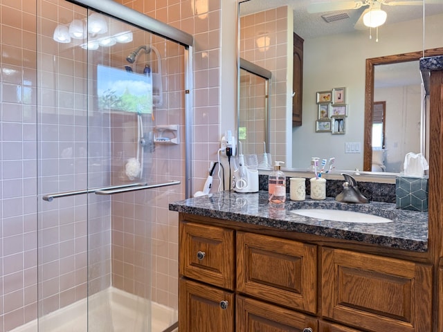 bathroom featuring a stall shower, vanity, and a ceiling fan