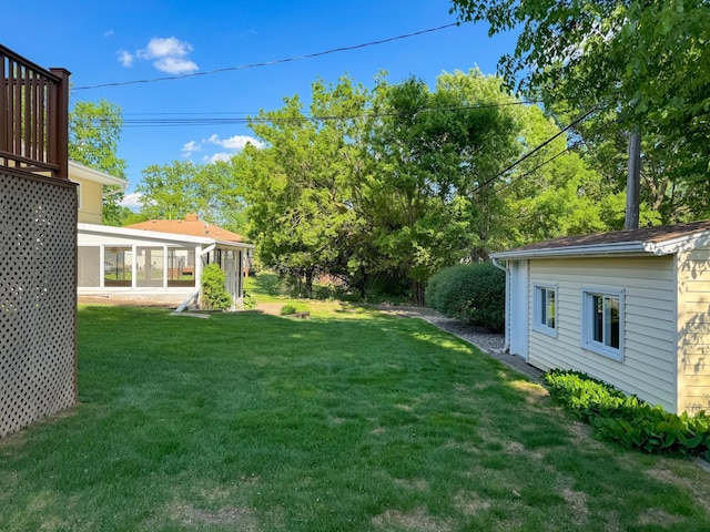 view of grassy yard with a sunroom
