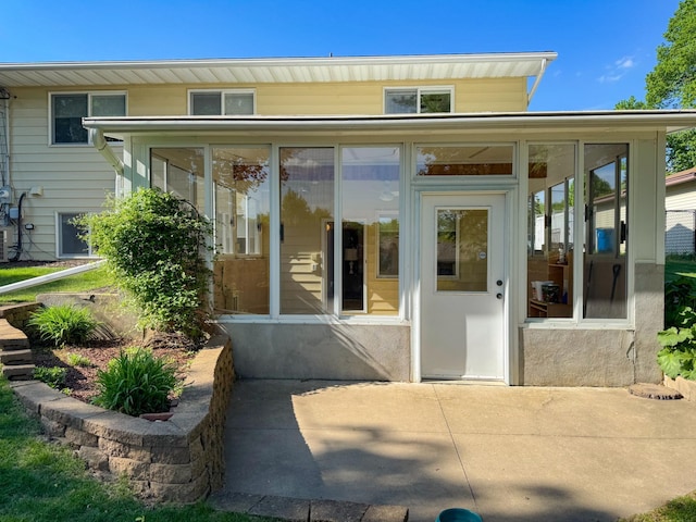 rear view of house featuring a sunroom and a patio