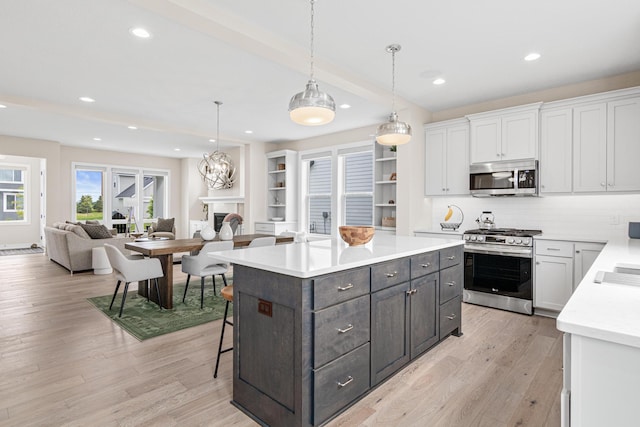 5068 Airlake Draw, Woodbury, MN 55129 - kitchen with stainless steel appliances, white cabinetry, light countertops, open floor plan, and recessed lighting