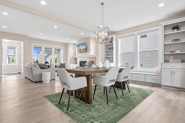 5068 Airlake Draw, Woodbury, MN 55129 - dining room featuring light wood-style floors, recessed lighting, a chandelier, a glass covered fireplace, and built in shelves