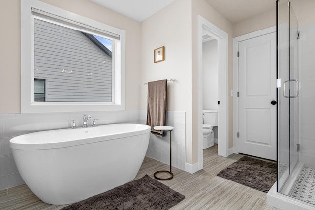 5068 Airlake Draw, Woodbury, MN 55129 - bathroom with a shower stall, a soaking tub, tile walls, toilet, and wainscoting