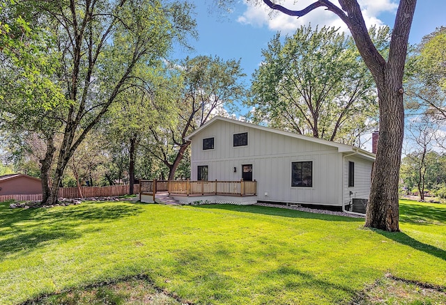 rear view of house featuring a deck, central AC, board and batten siding, and a chimney