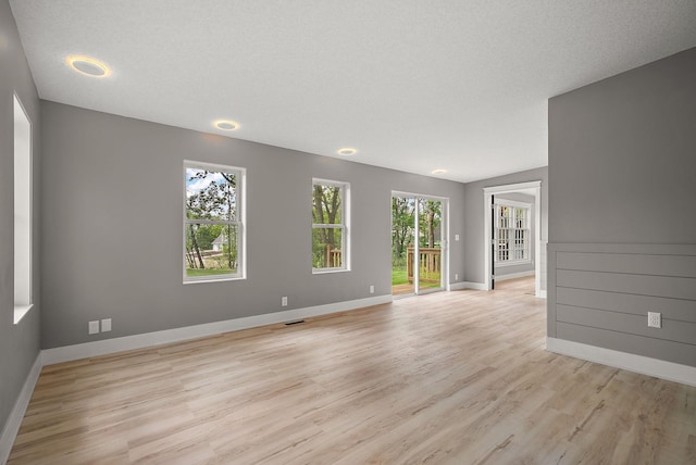 empty room with light wood-type flooring and baseboards