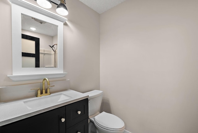 bathroom with toilet, vanity, and baseboards