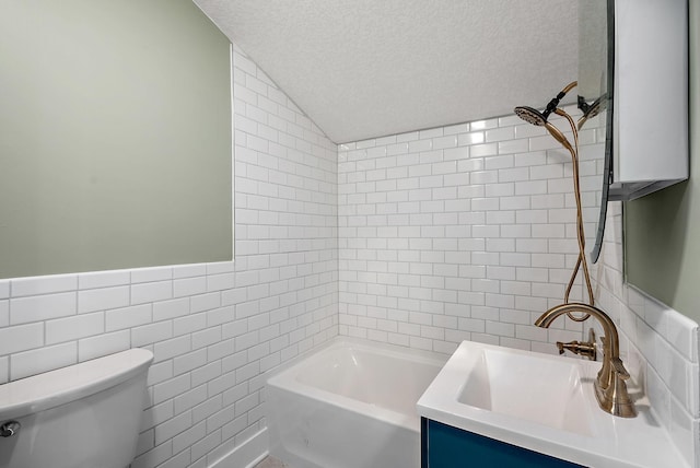 full bath with tile walls, vaulted ceiling, toilet, a textured ceiling, and vanity