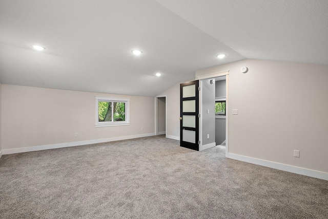 unfurnished room with lofted ceiling, carpet flooring, baseboards, and recessed lighting