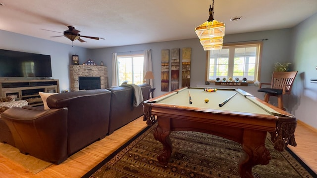 33401 Lakes Trl, Chisago Lake Twp, MN 55045 - rec room with a stone fireplace, light wood finished floors, a ceiling fan, and healthy amount of natural light