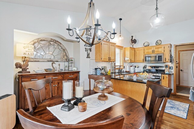 33401 Lakes Trl, Chisago Lake Twp, MN 55045 - dining area with a chandelier, wood finished floors, and vaulted ceiling
