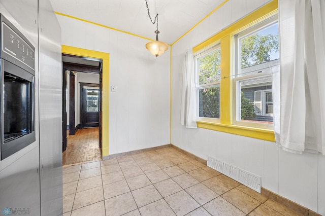 unfurnished dining area featuring light tile patterned floors and baseboards