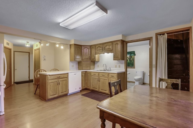 607 Wilson St, Downing, WI 54734 - kitchen with white appliances, a sink, light wood-style floors, a textured ceiling, and a peninsula