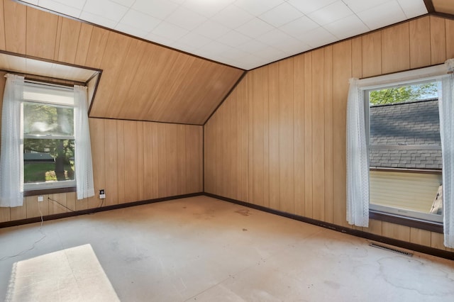 607 Wilson St, Downing, WI 54734 - additional living space with concrete flooring, lofted ceiling, wood walls, and baseboards