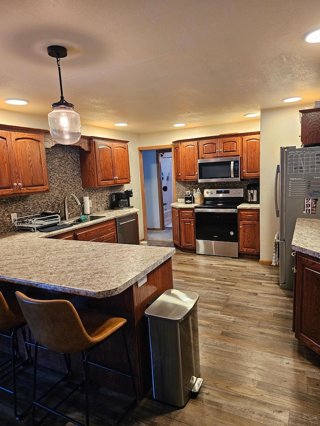 1005 8th Ave SW, Pipestone, MN 56164 - kitchen with appliances with stainless steel finishes, backsplash, a kitchen breakfast bar, a sink, and a peninsula
