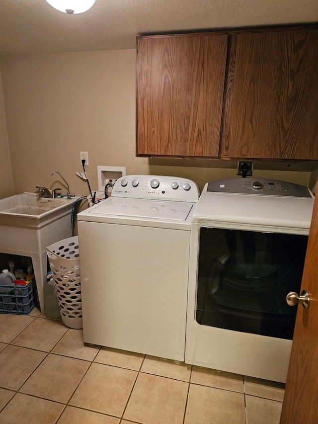 1005 8th Ave SW, Pipestone, MN 56164 - washroom with independent washer and dryer, light tile patterned floors, and cabinet space