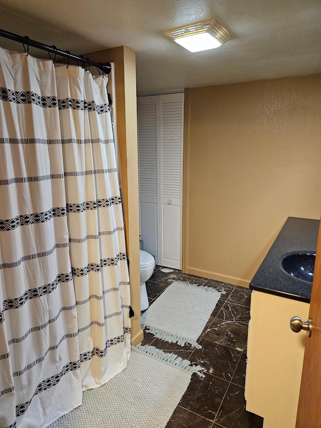 1005 8th Ave SW, Pipestone, MN 56164 - full bathroom with marble finish flooring, vanity, toilet, a closet, and a textured ceiling