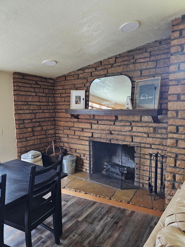 1005 8th Ave SW, Pipestone, MN 56164 - living area featuring a textured ceiling, wood finished floors, and a brick fireplace