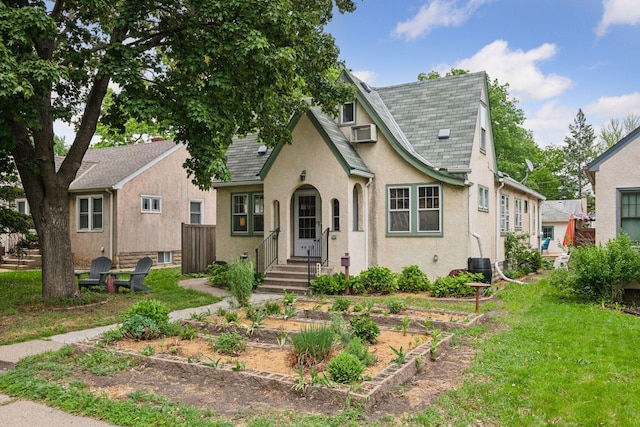 4613 34th Ave S, Minneapolis, MN 55406 - tudor house with stucco siding, a front yard, a shingled roof, and central air condition unit
