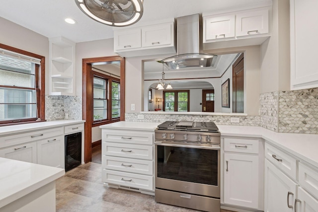 4613 34th Ave S, Minneapolis, MN 55406 - kitchen featuring stainless steel gas range, wine cooler, island exhaust hood, decorative backsplash, and white cabinetry