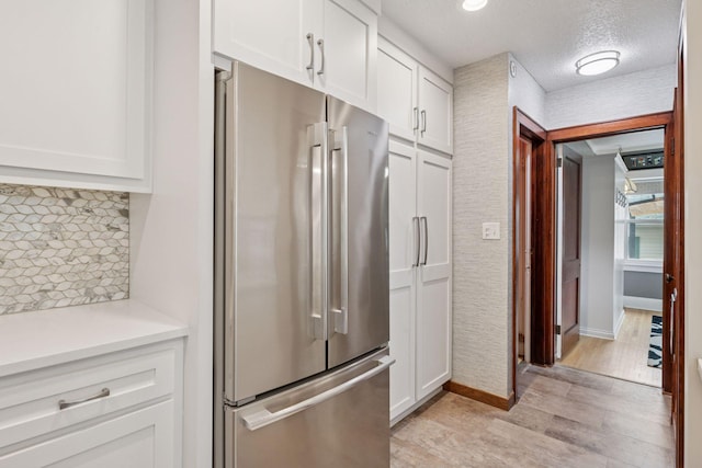 4613 34th Ave S, Minneapolis, MN 55406 - kitchen with freestanding refrigerator, light wood-type flooring, white cabinetry, light countertops, and a textured ceiling