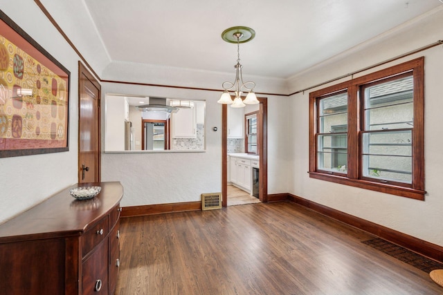 4613 34th Ave S, Minneapolis, MN 55406 - spare room featuring dark wood finished floors, baseboards, a chandelier, and crown molding