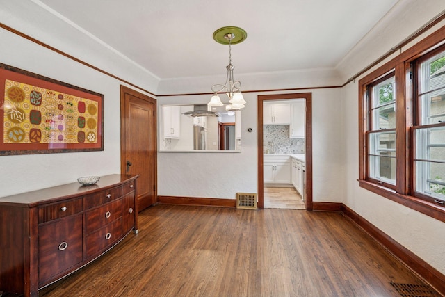 4613 34th Ave S, Minneapolis, MN 55406 - unfurnished dining area with dark wood finished floors, a chandelier, plenty of natural light, and baseboards