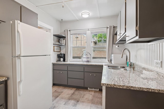 4613 34th Ave S, Minneapolis, MN 55406 - kitchen featuring freestanding refrigerator, a sink, gray cabinets, light wood finished floors, and light stone countertops