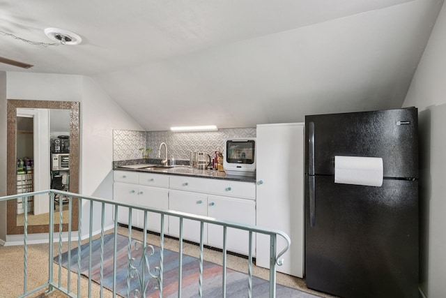 4613 34th Ave S, Minneapolis, MN 55406 - kitchen with freestanding refrigerator, dark countertops, lofted ceiling, white cabinets, and tasteful backsplash