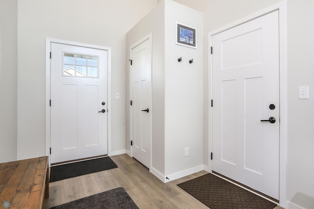 entryway with light wood-style flooring and baseboards