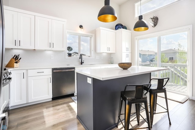 kitchen with dishwasher, a breakfast bar area, a sink, and healthy amount of natural light