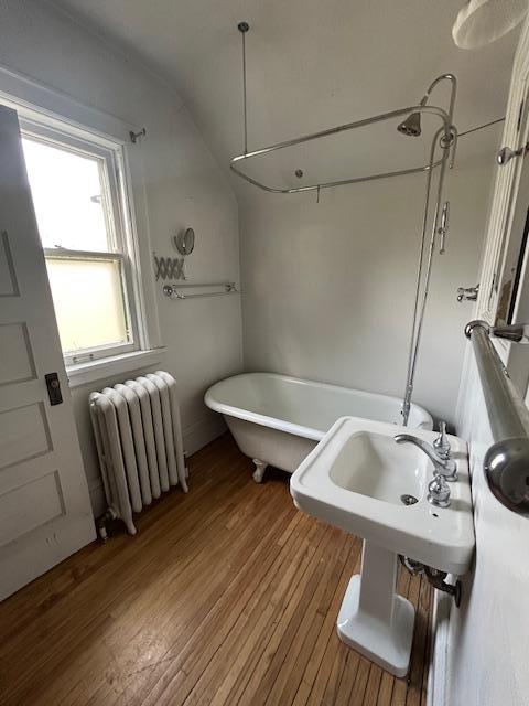 full bathroom with radiator, a freestanding bath, wood finished floors, and a shower