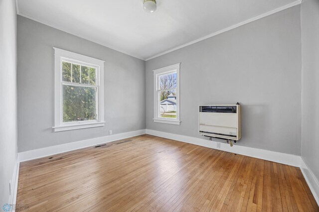 12 2nd St E, Ada, MN 56510 - unfurnished room featuring heating unit, plenty of natural light, crown molding, wood-type flooring, and baseboards