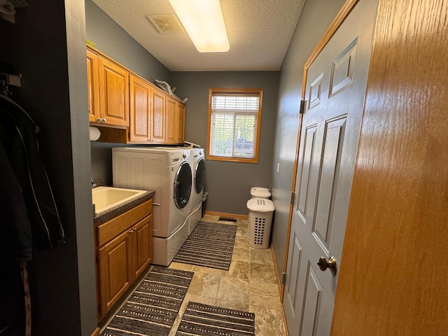 6158 Forest Boulevard Trl, Wyoming, MN 55092 - laundry area featuring independent washer and dryer, cabinet space, baseboards, a textured ceiling, and light stone finish floors
