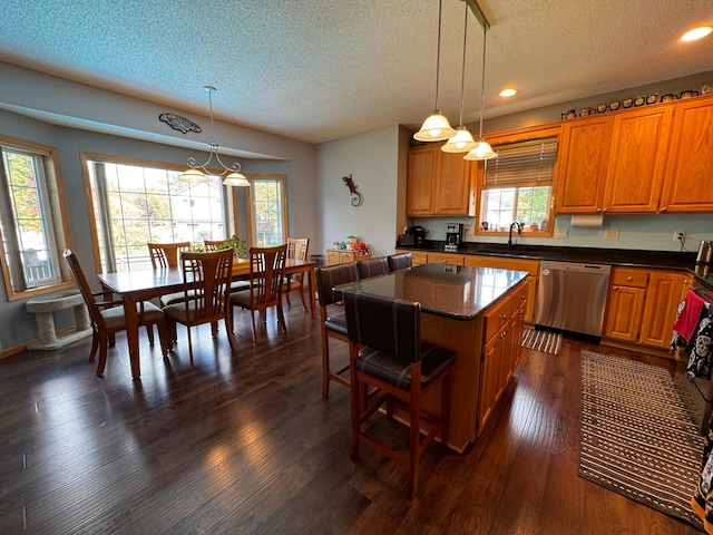 6158 Forest Boulevard Trl, Wyoming, MN 55092 - kitchen featuring stainless steel dishwasher, a textured ceiling, brown cabinetry, a center island, and a sink
