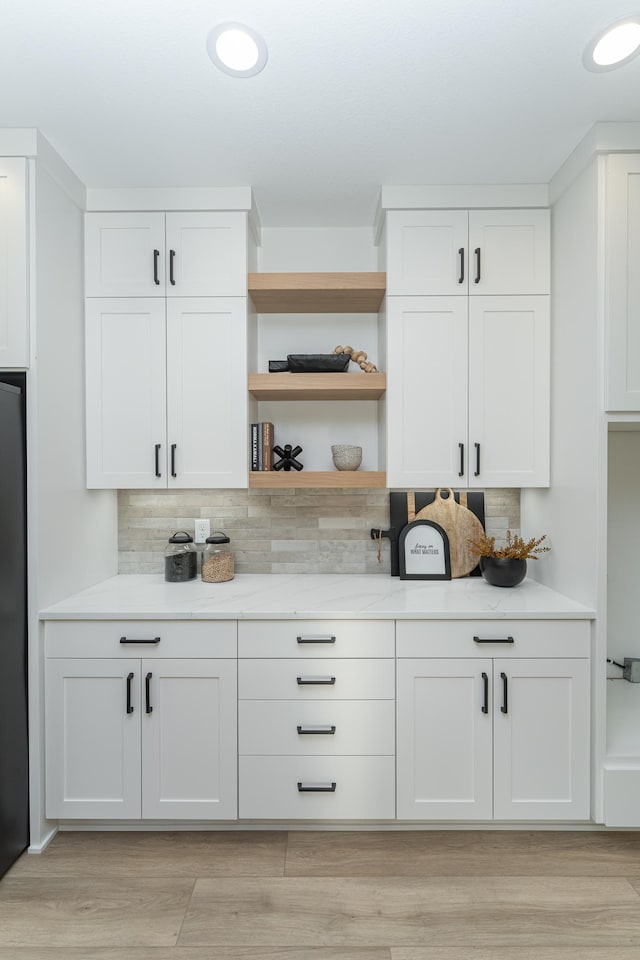 kitchen with tasteful backsplash, white cabinetry, light wood-style floors, and open shelves