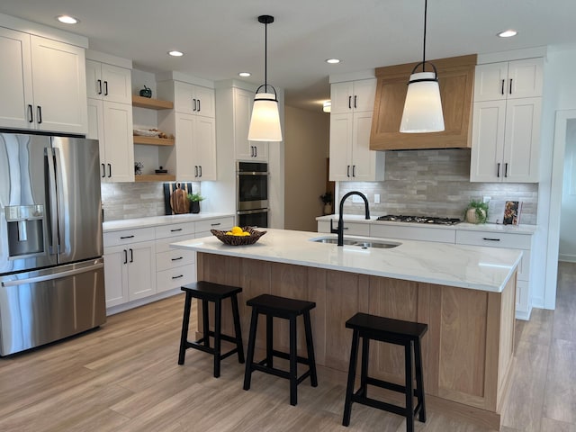 kitchen with stainless steel appliances, a sink, open shelves, tasteful backsplash, and white cabinetry
