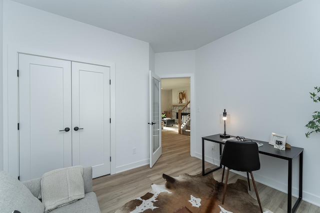 office space featuring light wood-style flooring, baseboards, and french doors