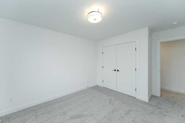 unfurnished bedroom featuring carpet, baseboards, and a closet