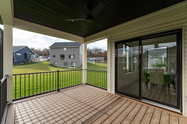 deck with a residential view, ceiling fan, and a lawn