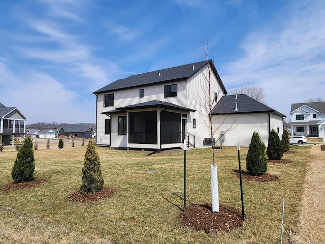 rear view of property featuring a sunroom and a lawn
