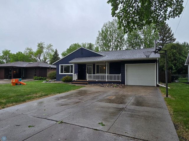 2105 7th St S, Moorhead, MN 56560 - view of front of property featuring covered porch, a garage, driveway, and a front lawn