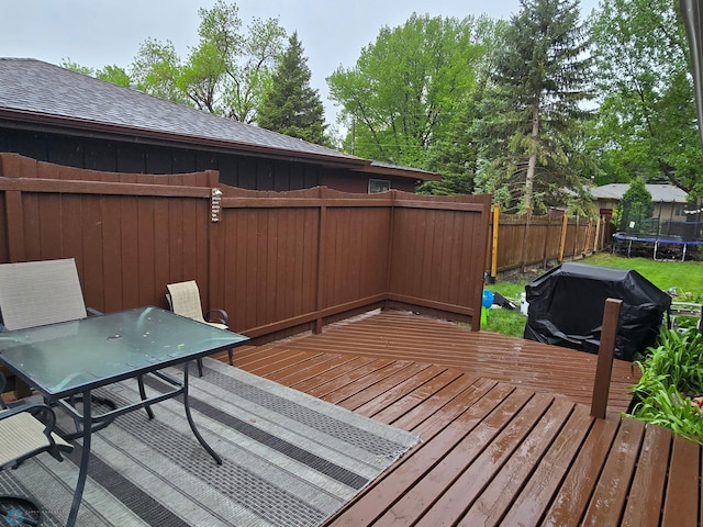 2105 7th St S, Moorhead, MN 56560 - wooden deck with a trampoline, a fenced backyard, and outdoor dining space