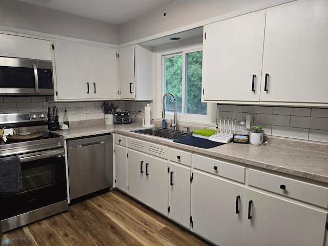 2105 7th St S, Moorhead, MN 56560 - kitchen featuring appliances with stainless steel finishes, a sink, tasteful backsplash, dark wood-style floors, and white cabinets