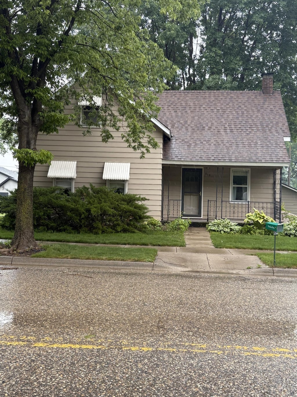 310 5th St, Henderson, MN 56044 - view of front of home with covered porch, a shingled roof, and a chimney