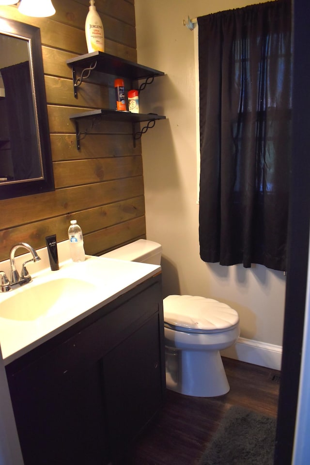 1706 Alcott Ave, Buse Twp, MN 56537 - bathroom featuring toilet, wood finished floors, vanity, and wooden walls