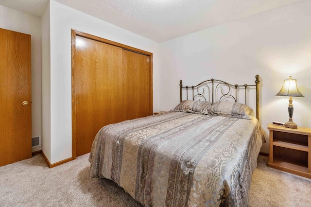 carpeted bedroom featuring a closet and a textured ceiling