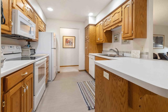 kitchen with white appliances, a sink, light countertops, light flooring, and recessed lighting