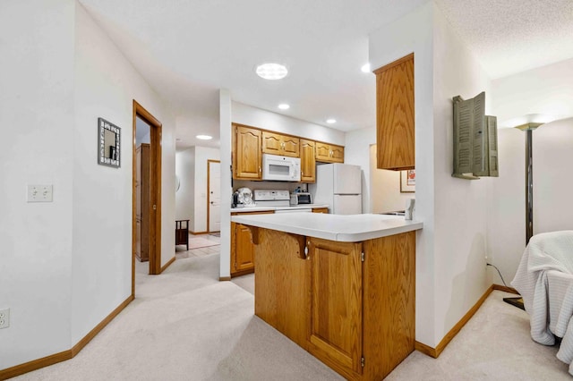 kitchen featuring white appliances, light colored carpet, baseboards, light countertops, and a peninsula