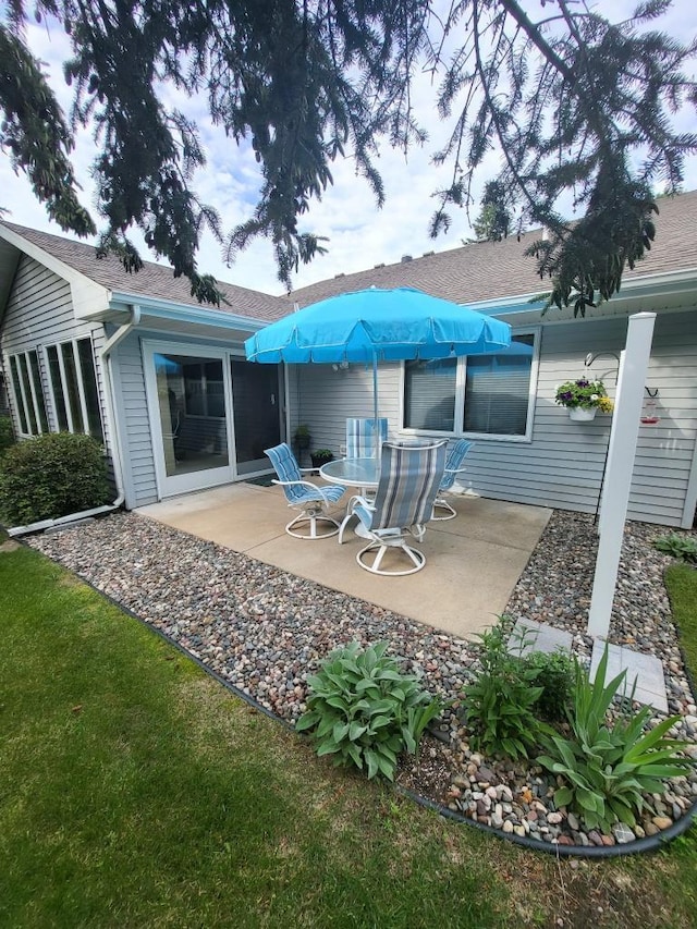 rear view of property with a patio and a shingled roof