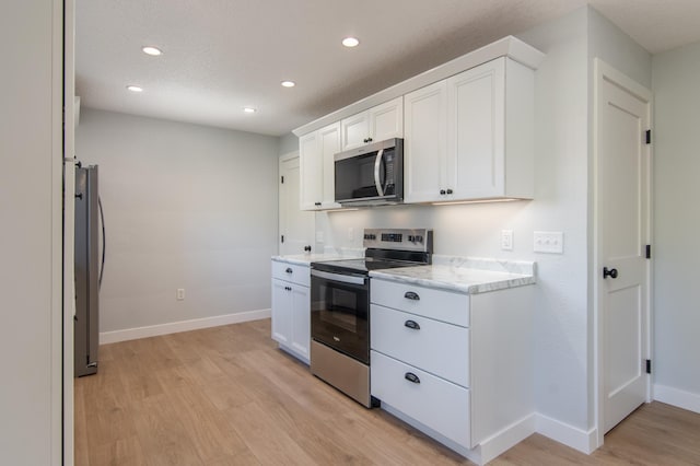 504 Wisconsin Ave N, Frederic, WI 54837 - kitchen featuring appliances with stainless steel finishes, light wood-type flooring, recessed lighting, baseboards, and white cabinetry